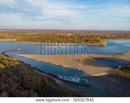 Cleaning and deepening by a dredger on the river. Ob river, Siberia, Russia