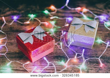 Christmas Present Box With Bow And Glitters Surrounded By Fairy Lights