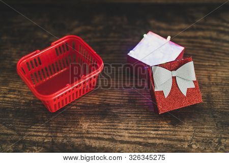 Christmas Present Box With Shining Fairy Lights Inside Next To Shopping Basket, Concept Of Gift Givi