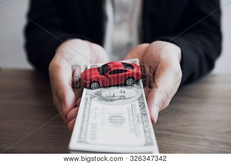 Car Salespeople Are Submitting Cash With Model Cars To Customers With Concept Of Buying A New Car.