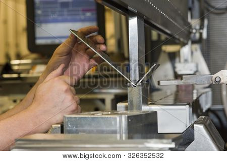 Worker Operating Metal Press Machine At Workshop. Bending Of Metal On The Machine.