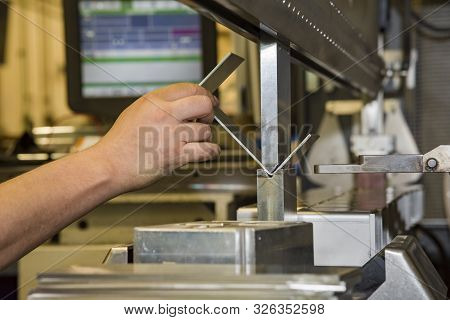 Worker Operating Metal Press Machine At Workshop. Bending Of Metal On The Machine.