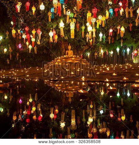 Buddha Image Surrounded By Candles And Colourful Lanterns. Beautiful Golden Buddha Image Lit By Cand