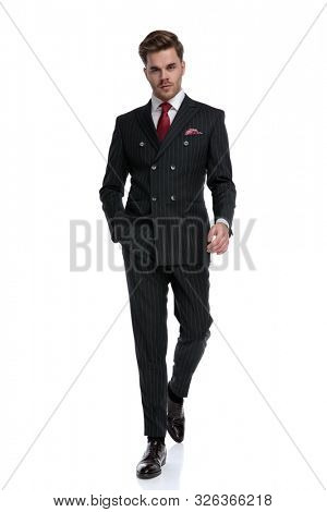 fashion businessman wearing double breasted suit and elegant brogue shoes, walking isolated on white background in studio