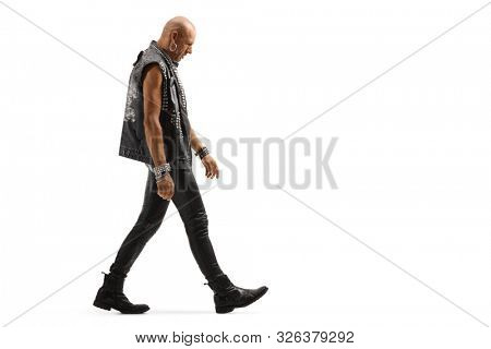Full length profile shot of a punker walking and looking down isolated on white background