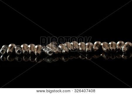Lot Of Whole Metallic Glossy Bolt In Row Isolated On Black Glass