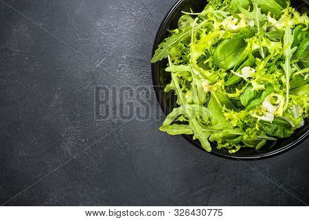 Green Salad Leaves Mix. Baby Spinach Leaves, Arugula And Frieze On Black Background. Top View With C