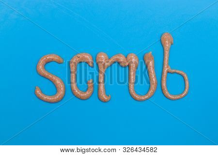 Word Scrub Made Of Brown Skin Scrub On A Blue Background