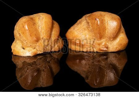 Group Of Two Halves Of Baked Golden Profiterole Isolated On Black Glass