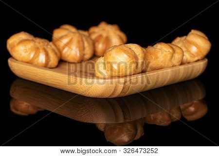 Group Of Six Whole Baked Golden Profiterole On Wooden Square Plate Isolated On Black Glass