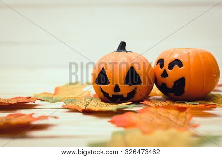 Halloween Pumpkins With Painted Faces On A Wooden Table. Halloween Background. Space For Text. Copy