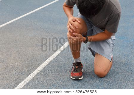 Sport Man Suffering With Pain On Sports Running Knee Injury After Running.injury From Workout Concep