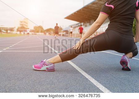 Young Woman Runner Stretching Legs Before Run - Workout Concept