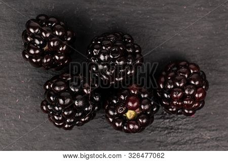 Group Of Five Whole Fresh Black Blackberry Flatlay On Grey Stone