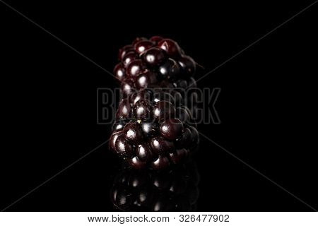 Group Of Two Whole Fresh Black Blackberry Isolated On Black Glass