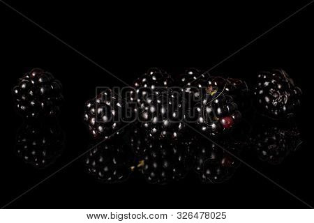 Lot Of Whole Dark Fresh Black Blackberry Isolated On Black Glass