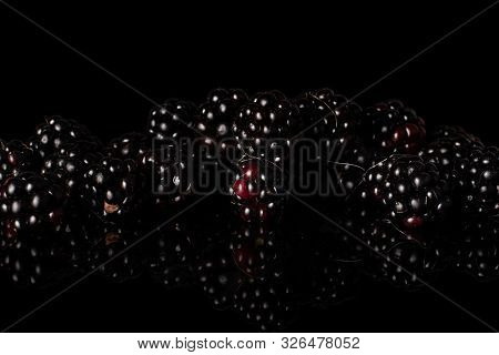 Lot Of Whole Arranged Fresh Black Blackberry Isolated On Black Glass