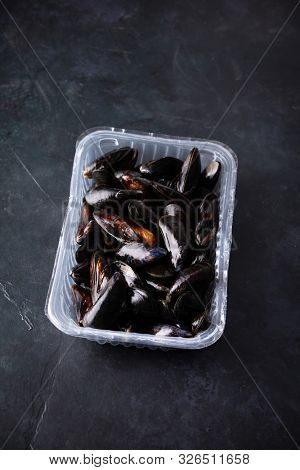 Fresh uncooked raw big mussels on dark background