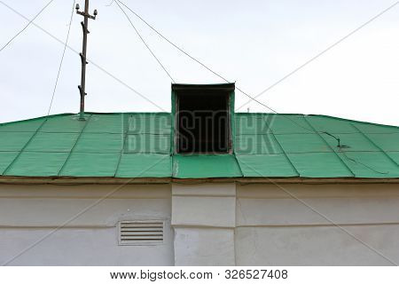 Old White Building With A Curved Green Roof And A Small Attic