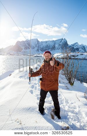 Fun Unsuccessful Fishing. Smiling Man With Fishing Rod And Tangled Fishing Line On The Background Of