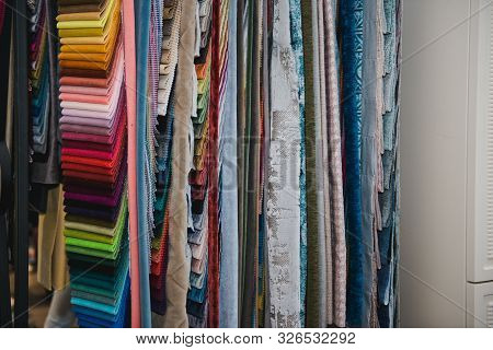 Many Fabrics Of Different Types. Colorful Fabric Swatches On Shopfront. Textile Samples Background.