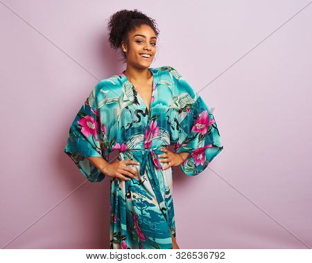 Young beautiful african american woman standing wearing elegant colorful caftan