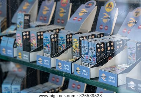 London, Uk - 4 October 2019: Many Brands Of Flavored Nicotine For E-cigarettes In Shop With Reflecti