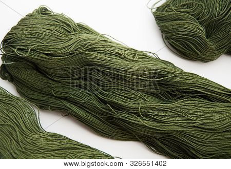 Closeup Of Fine Gauge Yarn Olive Green Isolated On A Light Background.  This Skein Or Hank Of Yarn I