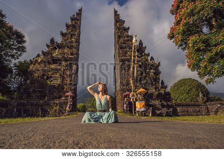 Tourist Woman Walking Through Traditional Balinese Hindu Gate Candi Bentar Close To Bedugul, Bratan 
