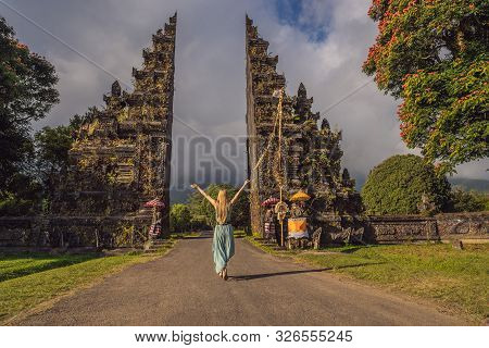 Tourist Woman Walking Through Traditional Balinese Hindu Gate Candi Bentar Close To Bedugul, Bratan 