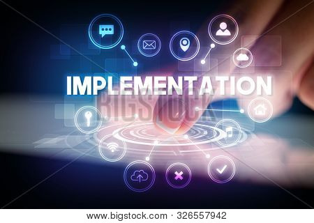 Finger touching tablet with web technology icons and IMPLEMENTATION inscription, web technology concept