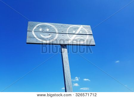 Smiling And Sad Face Symbols Written In The Blue Sky Background