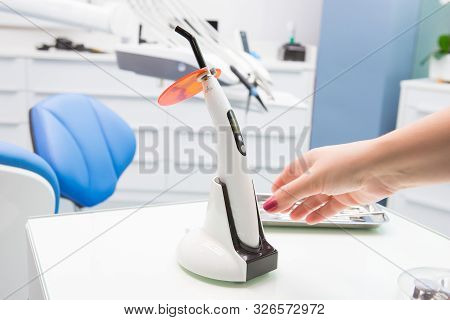 A Doctors Hand Holding A Polymerization Uv Lamp. Polymerization Lamp.