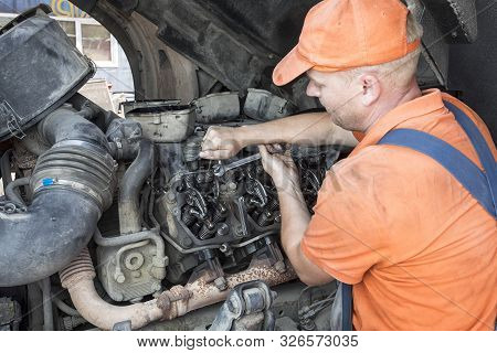 Mechanic Repairs A Truck. Adjustment Of Valves Of The Diesel Motor. Replacement Nozzles.
