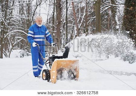 View From Side Bearded Man Wearing Blue Uniform Working With Snowblower And Removing Snow From Footp