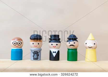 Wooden Doll With  Happy Face On Wooden Background.