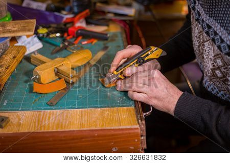 Professional Male Skinner, Tanner Working With Genuine Leather Belt At Workshop, Studio. Handmade An