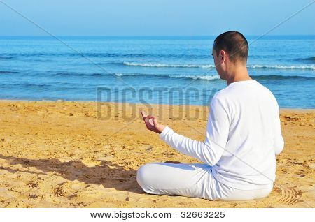 โยคีชายแต่งกายในการใคร่ครวญขาวในถ้อยหาด
