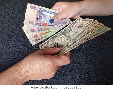 Women Hands Exchanging Belizean Banknotes And American Dollar Money