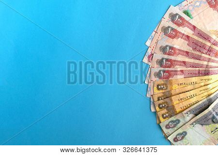 Uae National Currency, Dirhams Banknotes. Money Banknotes On Blue Background With Copy Space