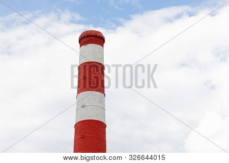 Red White Chimney On Blue Sky With Furry Clouds Background.