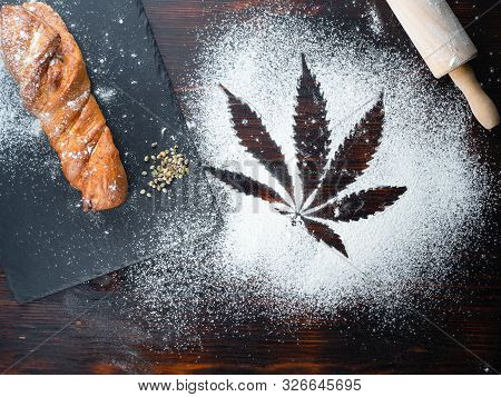 Cooking Cannabis Food. Trail Of Cannabis Leaf On White Flour. On A Wooden Table