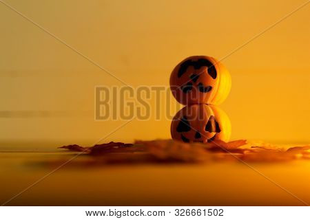 Halloween Pumpkins With Painted Faces On A Wooden Table. Halloween Background. Space For Text. Copy