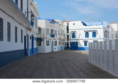 Old street  in the medina of Asilah with at one side the stone rampart to the beach
