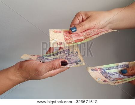 Women Hands Paying And Receiving Belizean Money