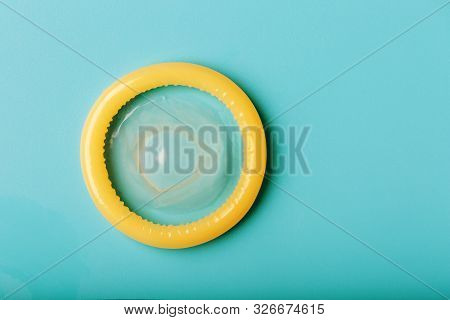 Opened Condom On A Blue Background. Use Of Protection To Reduce The Likelihood Of Sexually Transmitt