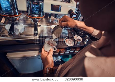 Diligent Barista Is Prepairing Fresh Latte For Customers For Coffee Break At Caffeteria.