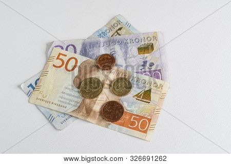 Some Swedish Crown Banknotes And Coins On A Wooden Surface