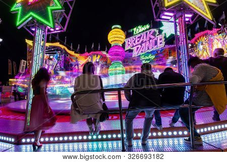 Munich, Germany, 2019 September 24: Visitors Enjoy The View Of An Amusement Park Ride At Night. Brea