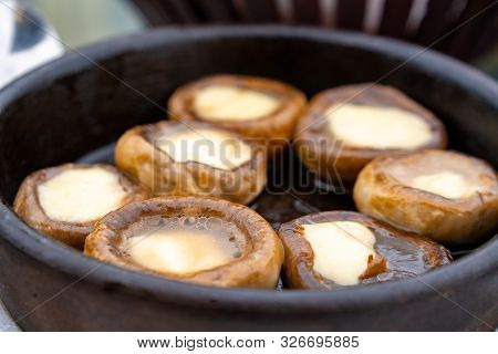 Close Up Mushrooms Baked With Cheese Suluguni On Ketsi. Georgian Cousine.
